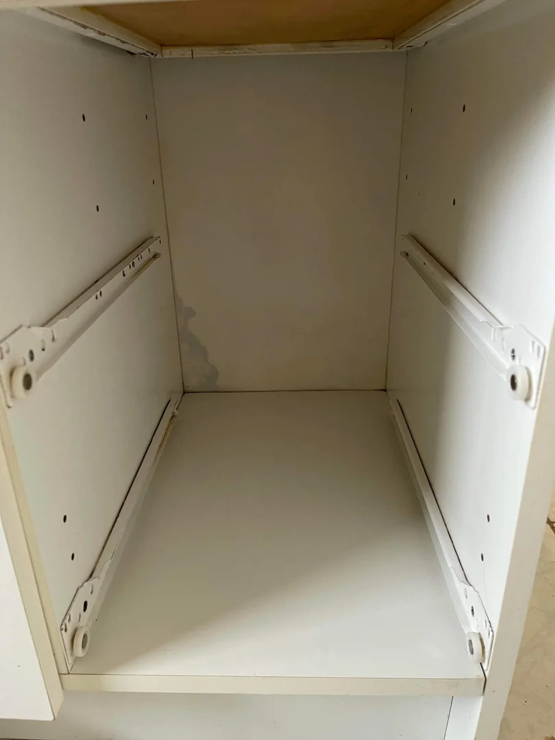 Same kitchen cabinet interior after cleaning — bright white shelf, free of dirt and debris.