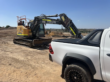 White truck with yellow excavator