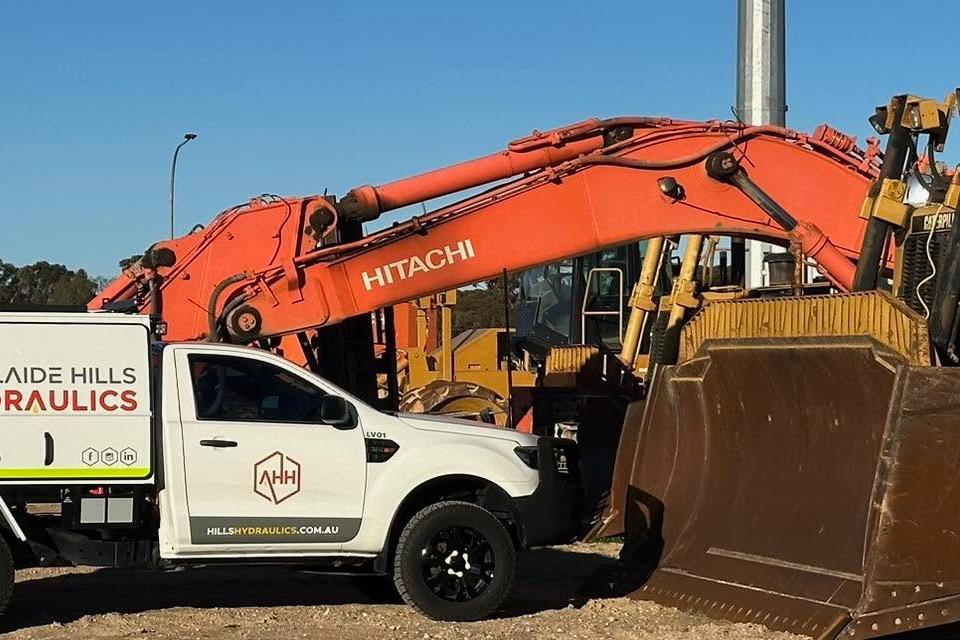 Adelaide Hills Hydraulics mobile service vehicle beside a Hitachi excavator
